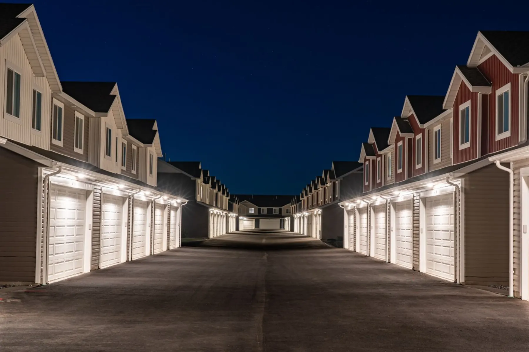 Newly built townhome-style housing with attached garages at night in Hyrum, Utah